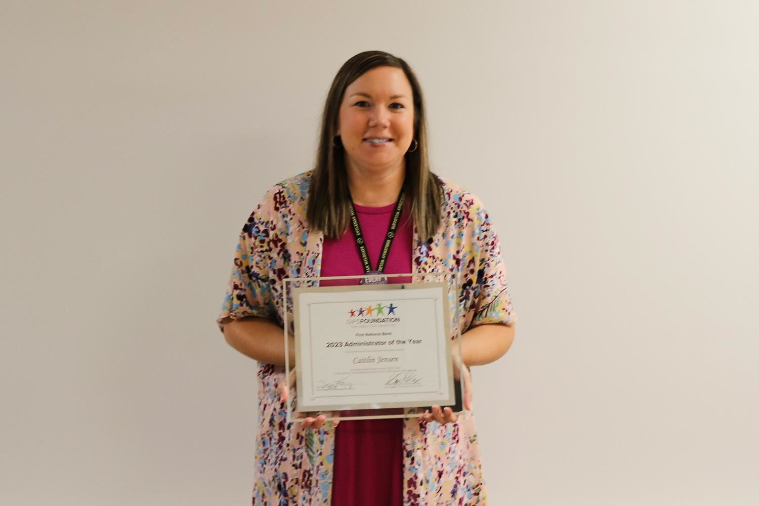 Caitlin Jensen standing with her Administrator of the Year plaque